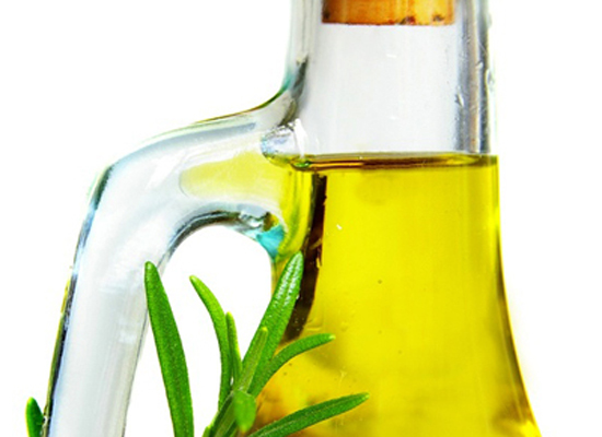 Closeup of olive oil and rosemary, isolated on white