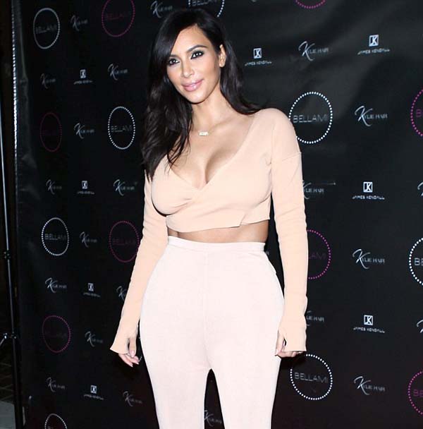 Kim Kardashian beams with pride as she poses in plunging 