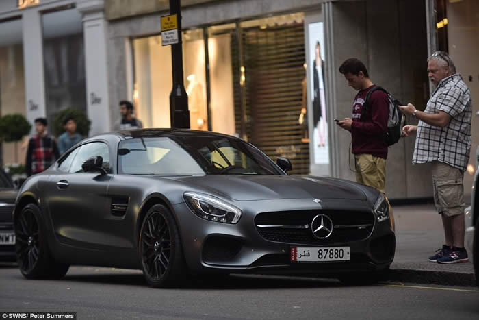 Two passers-by stop to admire one of the supercars, a Mercedes-Benz AMG GT, worth around £110,000,