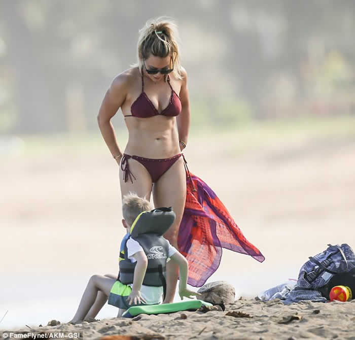 Hilary Duff shows off her toned torso in a bikini as she lar